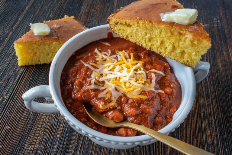 bowl of chili with corn bread on table