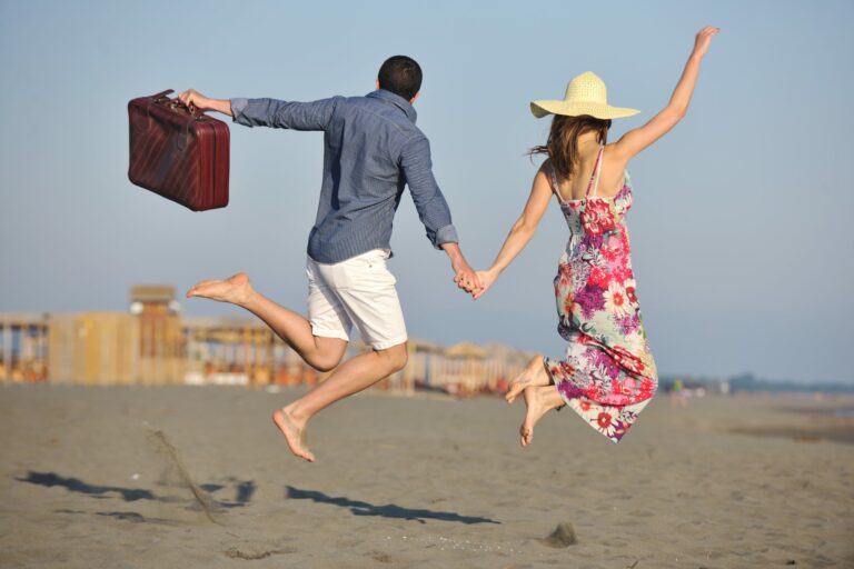 couple on beach with travel bag buying vacation property in mexico