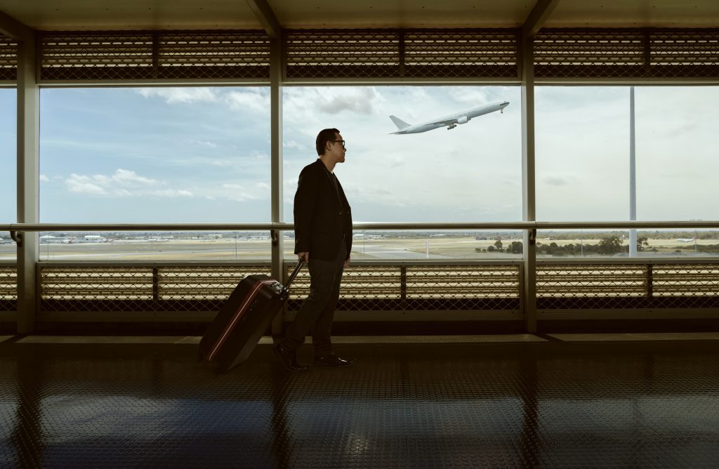 man-luggage-walking-in-mexican-airport-terminal-and-air-plane-flying