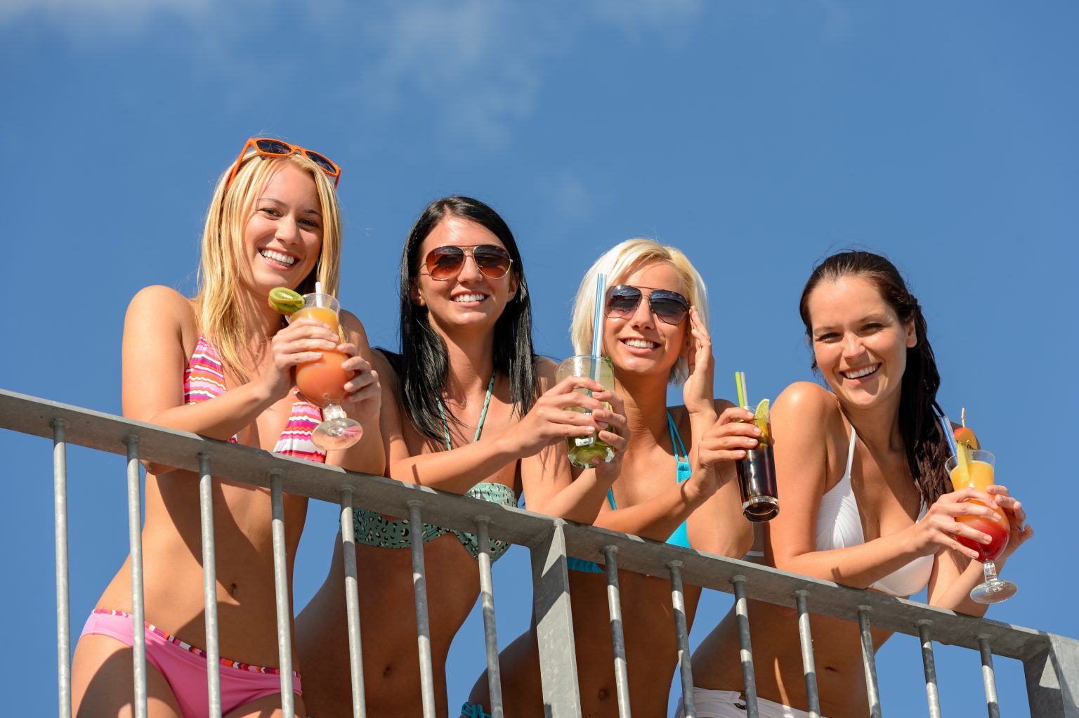 women in bikinis smiling with mexican cocktails
