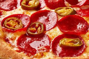closeup pepporoni mexican pizza with slices jalapenos melted cheese
