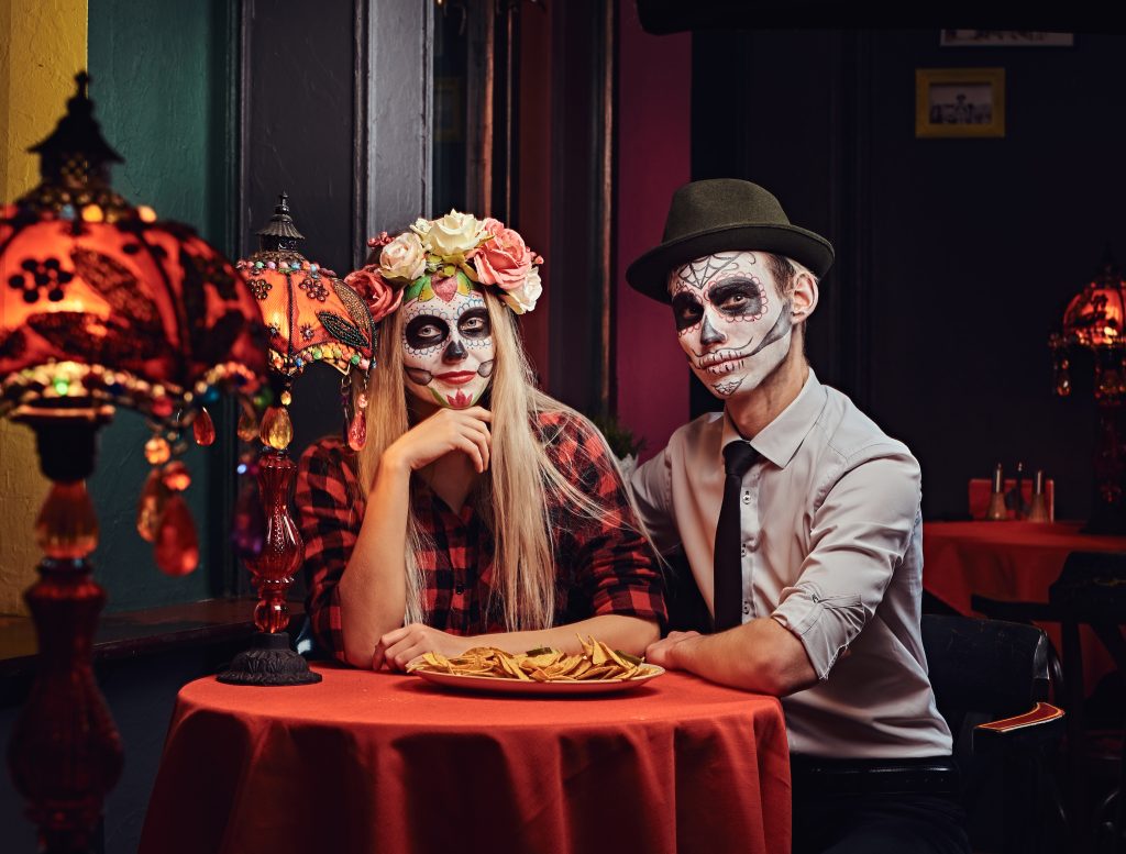 day of dead costumes on couple dating at mexican restaurant in december