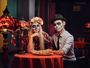 day of dead costumes on couple dating at mexican restaurant